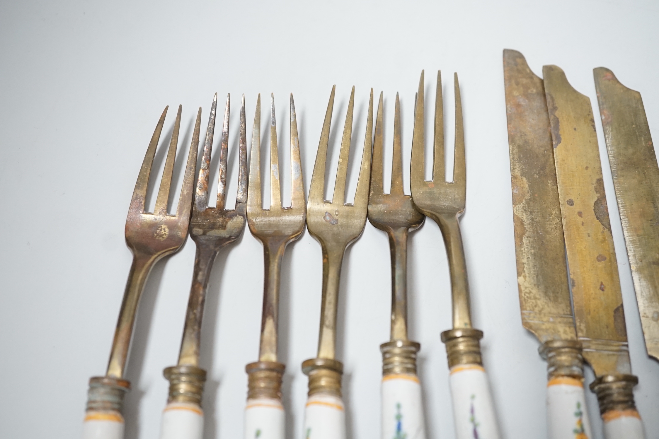 Six pairs of French Faience pistol grip handled knives and forks